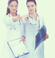 Fototapeta premium Two woman nurse watching X Ray image, standing in hospital, pointing you