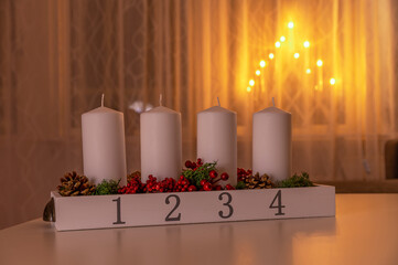 Four white advent candles on table with electic advent candlestick on background, the christmas...