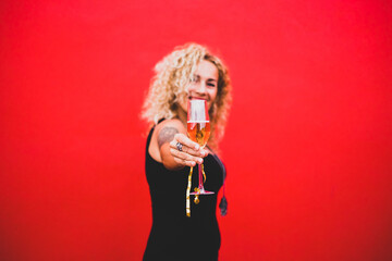 portrait beautiful curly woman celebrating new year 2021 smiling and looking at the camera holding a glass or cup with champagne