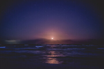 Fototapeta na wymiar Beautiful full moon over the sea in a night with stars