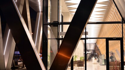 Obraz premium Combination of metal and glass wall material. Steel facade on columns. Abstract modern architecture. High-tech minimalist office building. Contemporary business architecture abstract fragment in night