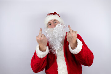 Man dressed as Santa Claus standing over isolated white background showing middle finger doing fuck you bad expression, provocation and rude attitude. screaming excited