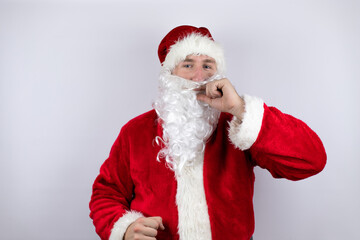 Fototapeta na wymiar Man dressed as Santa Claus standing over isolated white background with mouth and lips shut as zip with fingers. Secret and silent, taboo talking