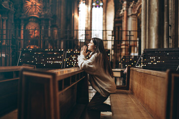 Christian woman prays in church. Hands crossed on wooden table. Christian Background