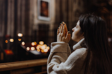 religion, faith, harmony and people concept: the parishioner of the church sits on a bench with her...