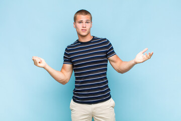 blonde  man shrugging with a dumb, crazy, confused, puzzled expression, feeling annoyed and clueless