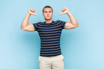 blonde  man feeling proud, arrogant and confident, looking satisfied and successful, pointing to...