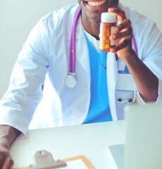 Close-up of male doctor giving jar of pills to patient.