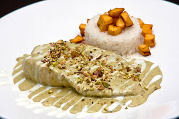 Pechuga de pollo con mole de pistache y arroz con platano macho frito