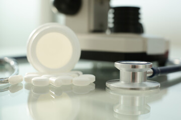 Pill stethoscope and microscope on glass table