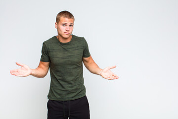 blonde  man feeling puzzled and confused, unsure about the correct answer or decision, trying to...