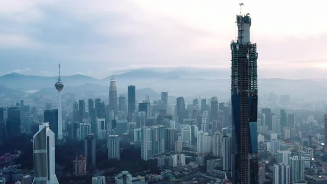 Establishing aerial cinematic drone b-roll shot of sunrise at Kuala Lumpur city skyline