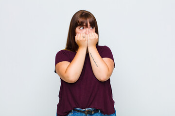 overweight woman looking worried, anxious, stressed and afraid, biting fingernails and looking to...