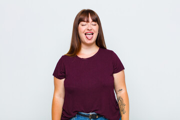 overweight woman with cheerful, carefree, rebellious attitude, joking and sticking tongue out,...