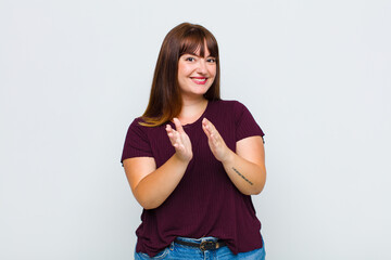 overweight woman feeling happy and successful, smiling and clapping hands, saying congratulations...