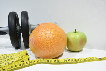 Fitness tools for home, measuring tape and fresh fruits. Fatburning, diet and sport lifestyle