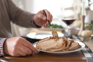 Man taking sliced turkey from a platter