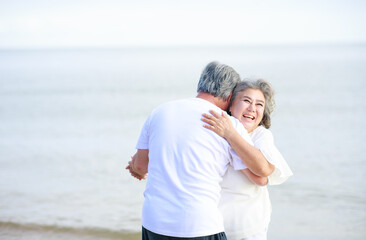 Asian senior love couple travel relaxing on the beach. Retirement and recreation on summer holiday.