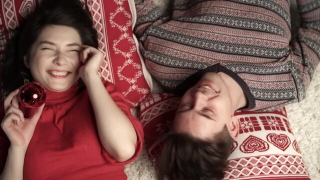 Happy couple having fun at xmas eve and lying head to head. Top view. Relationship, family, christmas, new year, holiday concet.