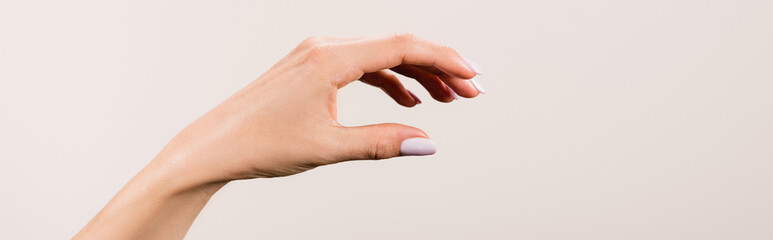 cropped view of female hand isolated on grey, 