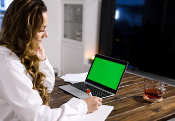 Young business women at her laptop green screen display - home shooting