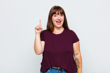 overweight woman feeling like a happy and excited genius after realizing an idea, cheerfully...