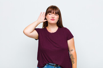 overweight woman looking serious and curious, listening, trying to hear a secret conversation or...