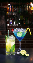 Classic blue triple sec cocktail and a margarita with refreshing summer mint with a citrus lemon flavor and with a cherry on top for decoration, ideal for celebrations