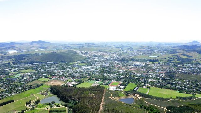 Aerial drone Stellenbosch green landscape and fields with forests and residential town and neighbourhood with houses and buildings
