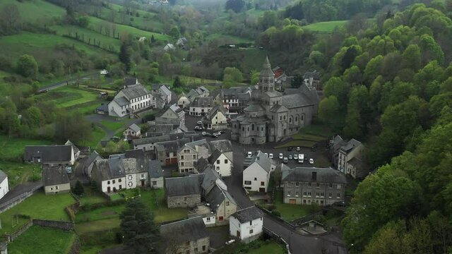 Beautiful green valley surrounding a cute French hamlet and church. Dolly away.