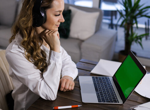 Young business woman with her laptop - green screen display - home shooting