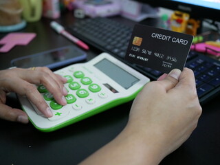 woman hand holding creadit card with calculator for shopping online.