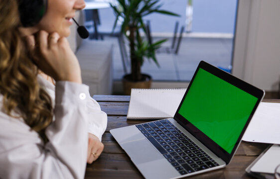 Young business woman with her laptop - green screen display - home shooting