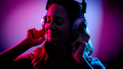 Young woman listens to music on her headphones - stylish illuminated - home shooting