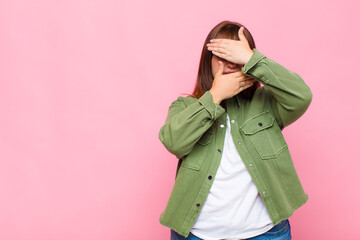 overweight woman covering face with both hands saying no to the camera! refusing pictures or...