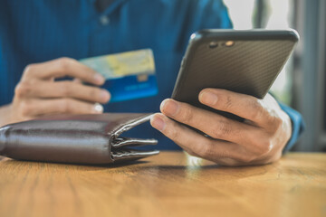 Close up hand holding mobile phone shopping online with credit card soft focus