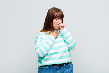 overweight woman feeling ill with a sore throat and flu symptoms, coughing with mouth covered
