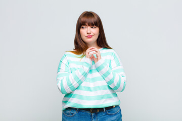 overweight woman feeling proud, mischievous and arrogant while scheming an evil plan or thinking of...