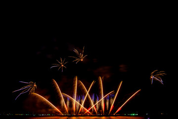 colorful fireworks,Beautiful multi color fireworks explosions lighting sky over trees silhouette...