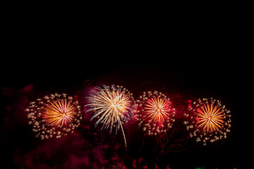 colorful fireworks,Beautiful multi color fireworks explosions lighting sky over trees silhouette and over an illuminated,celebration concept