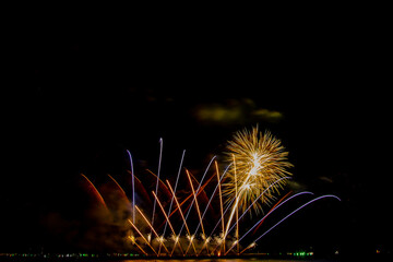 colorful fireworks,Beautiful multi color fireworks explosions lighting sky over trees silhouette and over an illuminated,celebration concept