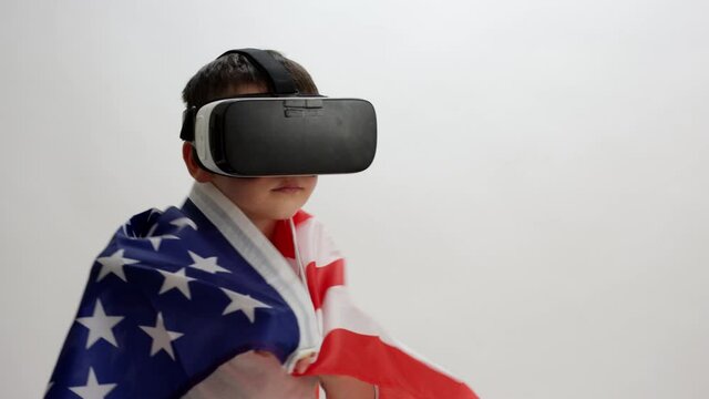 Toddler boy experiencing virtual reality - adjusts american flag on on shoulders - uncomfortable