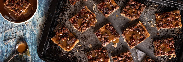 Top down view of caramel pecan chocolate chip squares on a sheet pan ready for eating. - obrazy, fototapety, plakaty