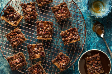 Top down view of caramel pecan chocolate chip squares on a round cooling rack.