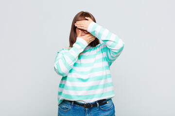 overweight woman covering face with both hands saying no to the camera! refusing pictures or...