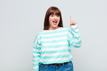 overweight woman feeling like a happy and excited genius after realizing an idea, cheerfully...