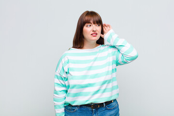overweight woman looking serious and curious, listening, trying to hear a secret conversation or...