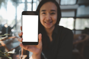 Happy Woman Showing Blank Smartphone Screen in cafe, mockup mobile phone with blank white screen.