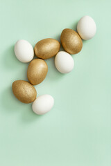 Decorated Easter golden and white eggs on green background. Happy Easter card, postcard