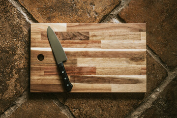 Chef&#39;s knife on a wooden cutting board flatlay